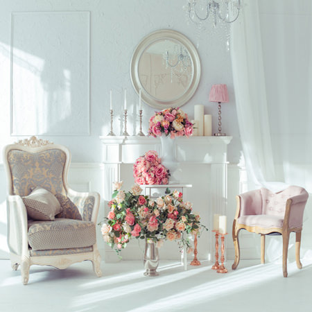 two white chairs with a table in the middle with pink flowers
